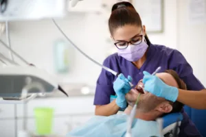 Dentiste en tenue violette soignant un patient