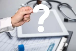 Point d’interrogation sur une tablette posée à côté d’un stéthoscope