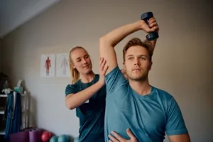 Kinésithérapeute accompagnant un patient dans un exercice avec haltère