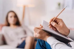 Psychologue prenant des notes face à une patiente