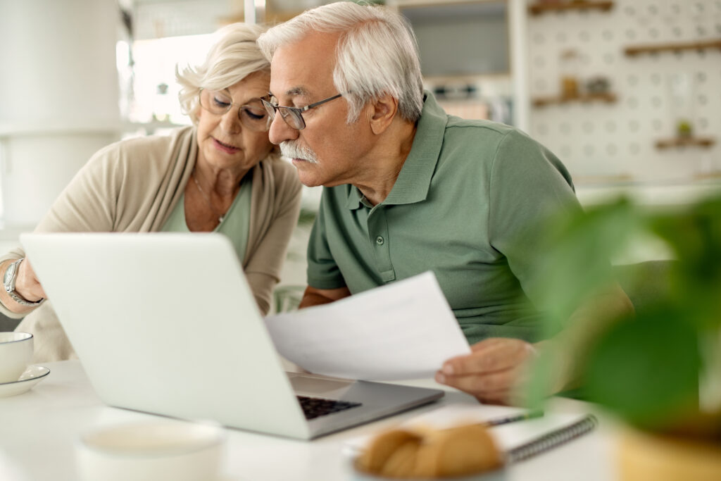 Couple de seniors analysant leur épargne et leurs finances à la maison
