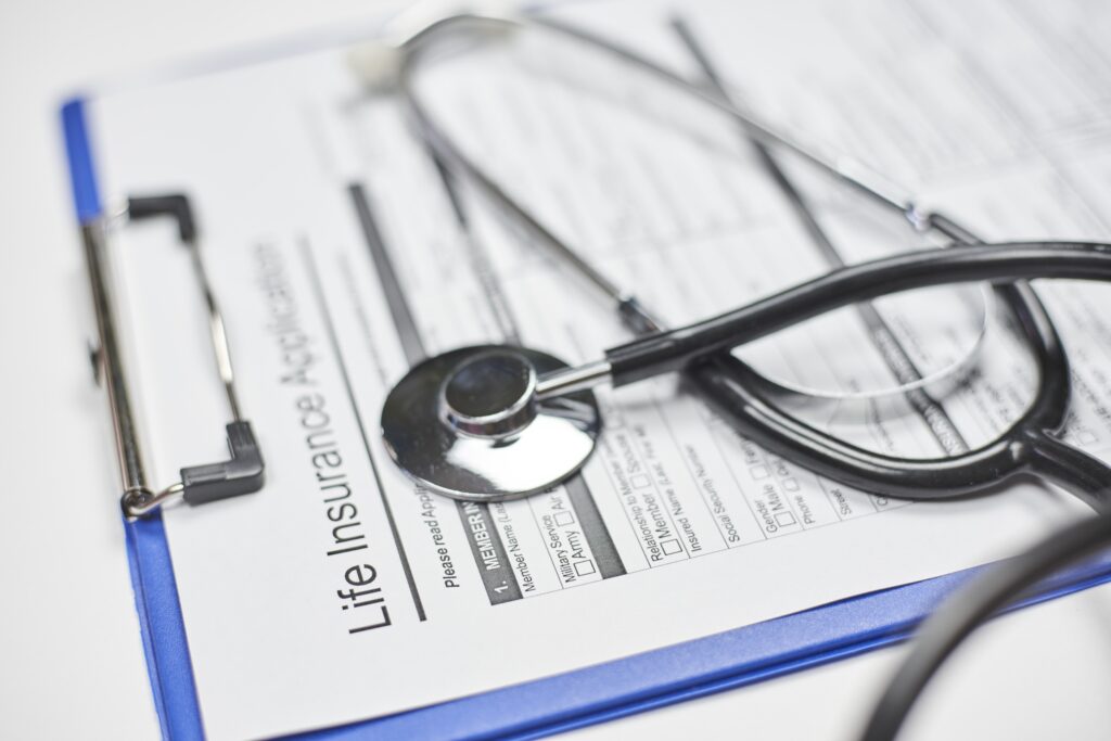 Formulaire d’assurance vie vierge et stéthoscope sur un presse-papiers