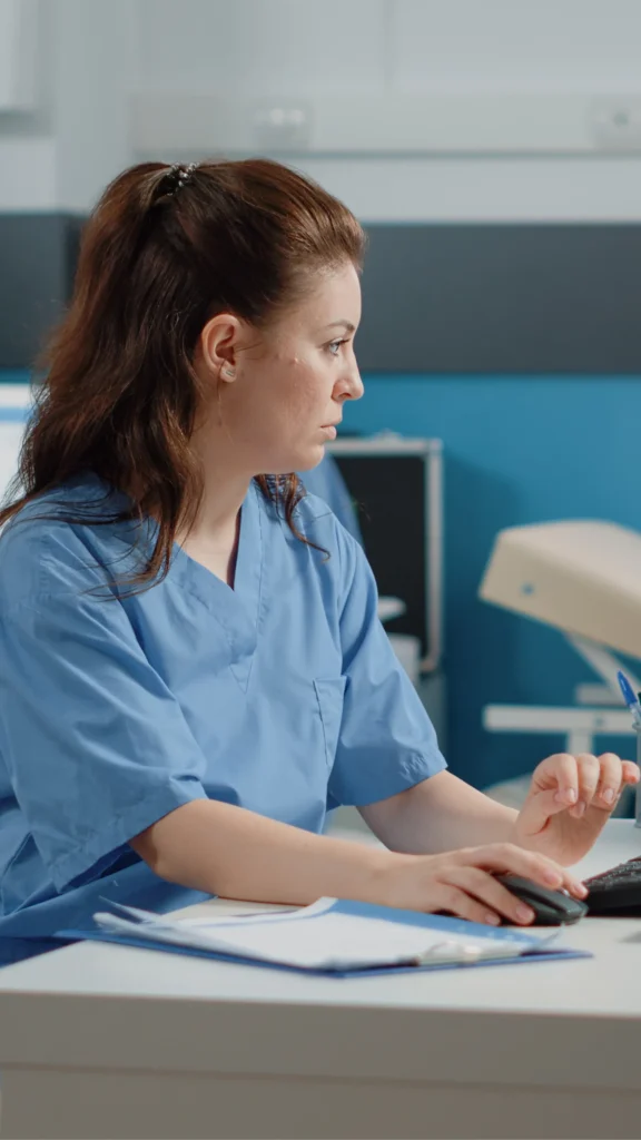 Infirmière travaillant sur ordinateur à son bureau