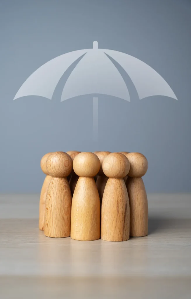 Des figurines en bois protégées par un parapluie : la prévoyance pour les professions de santé