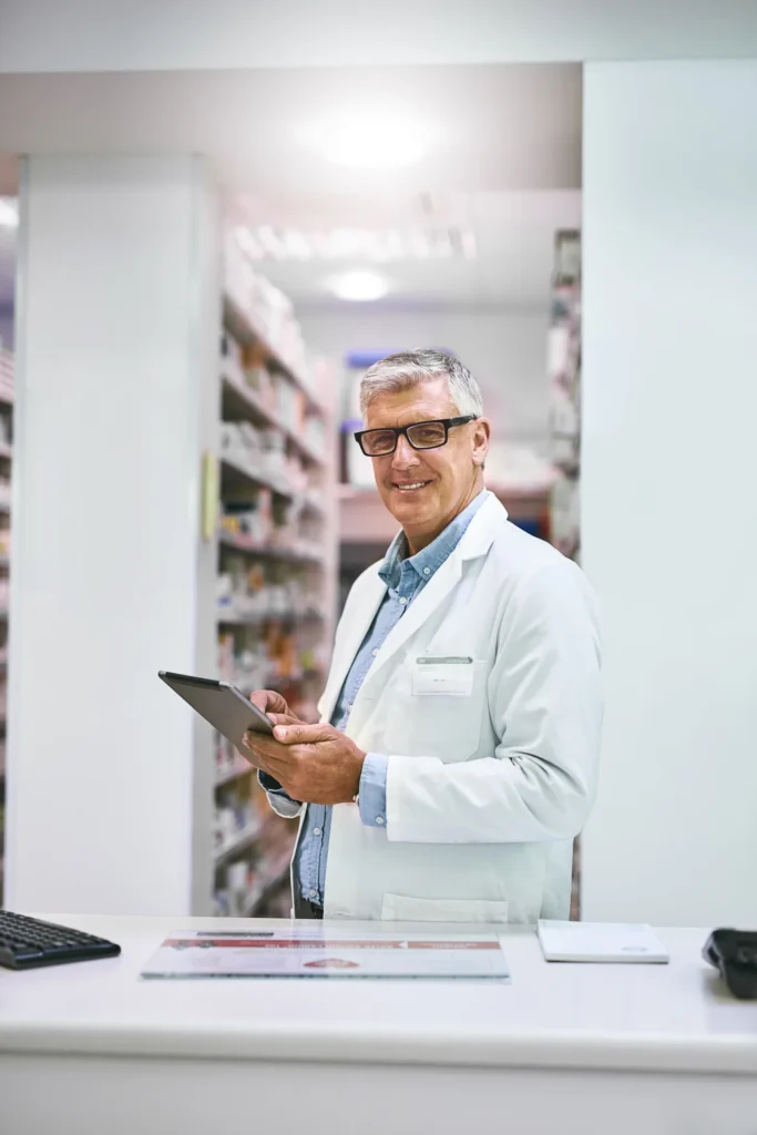Pharmacien consultant une tablette dans son officine – PER-in pour pharmaciens