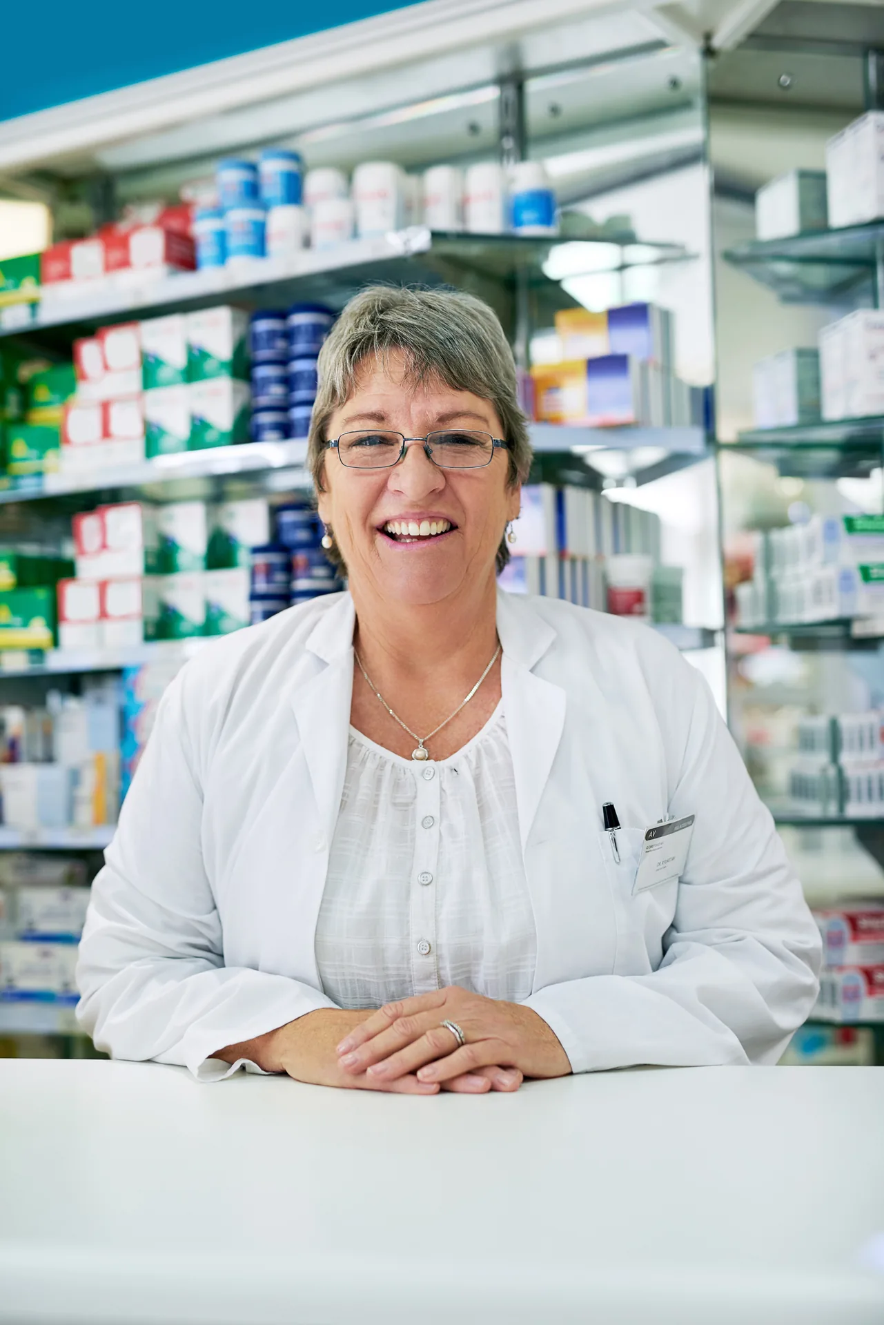 Pharmacienne au comptoir de son officine – prévoyance pour pharmaciens