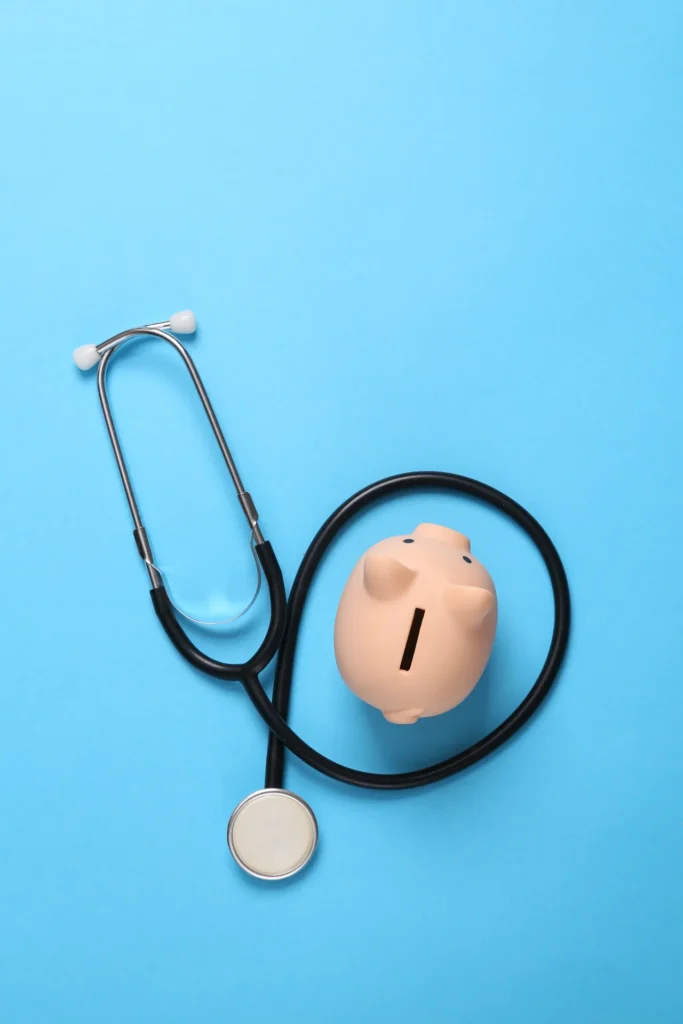 Tirelire et stéthoscope sur fond bleu : épargne et assurance vie pour les professions de santé